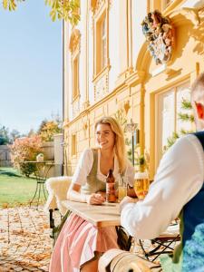 kobieta siedząca przy stole na patio w obiekcie TAUROA Hofwirt w mieście Seckau