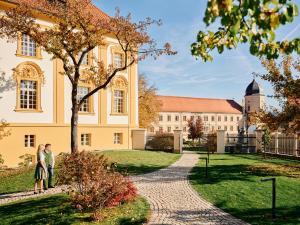 dwie osoby stojące przed budynkiem w obiekcie TAUROA Hofwirt w mieście Seckau