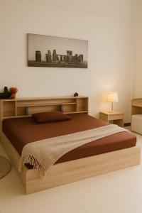 ein Schlafzimmer mit einem großen Bett mit Holzrahmen in der Unterkunft Green Terrace Residence Phuket in Kathu