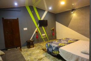 Un dormitorio con una cama y un televisor en la pared. en Green Infinity Resort,  13 fotos más