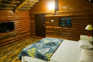 Un dormitorio con una cama en una cabaña de madera. en Green Infinity Resort, 