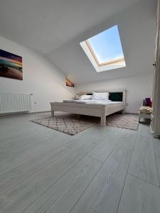 a white room with a bed and a skylight at CASA DIN DEAL in Roşia Montană