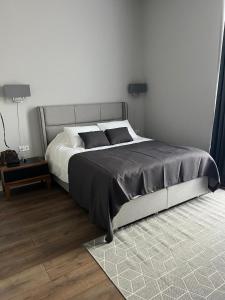 a bedroom with a large bed with a black blanket at Villa, Kachreti Ambassador Golf Resort in Stantsiya Kachreti