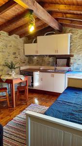 una cocina con armarios blancos y una mesa en una habitación en Refúgio do Casal, en Lousã