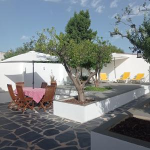a table and chairs with a tree in a patio at Casa da Vila in Mourão