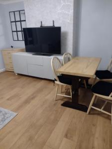 a living room with a table and a tv at Gilmerton Dykes Av in Edinburgh
