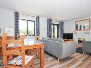 a living room with a table and a couch at Columbine Cottage in Bude