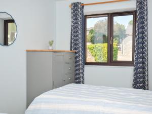 a bedroom with a bed and a window at Columbine Cottage in Bude +16 photos