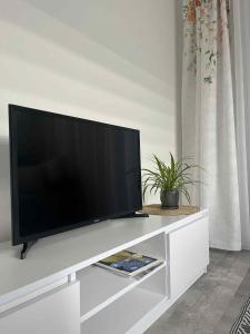 a flat screen tv sitting on top of a white entertainment center at Apartament LUCA in Oleśnica +21 photos