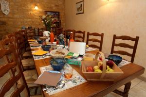 a wooden table with a basket of fruit on it at Le Pigeonnier de Labrot in La Roque-Gageac