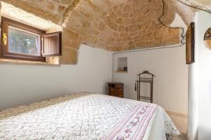 Ένα ή περισσότερα κρεβάτια σε δωμάτιο στο Il Trullo del Pellegrino by BarbarHouse