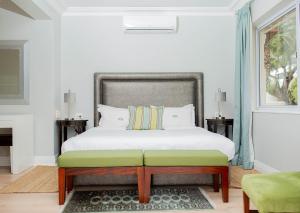 a bedroom with a bed with a bench in it at Vetho Villa in Cape Town +64 photos
