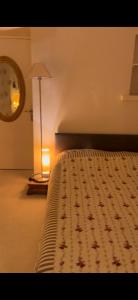 a bedroom with a bed with a lamp and a clock at Clos de la filature sauna et bien-être in Ronchamp