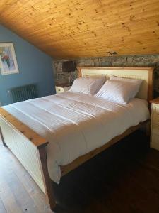 un grande letto in una camera da letto con soffitto in legno di Cloneymore Guest House ad Athboy Altre 2 foto