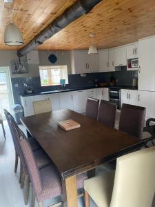 una cucina con un grande tavolo in legno e sedie di Cloneymore Guest House ad Athboy