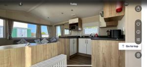 a kitchen with wooden cabinets and a counter top at Newquay Bay Resort getaway in Porth