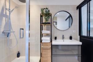 un bagno con lavandino e specchio di Le Herriot Hyper Centre 5min de la Gare à pied a Brive-la-Gaillarde