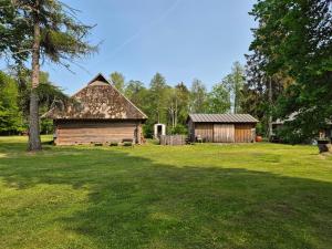 an old cabin and a barn in a field at Karjalasma Mägramaja in Pöitse