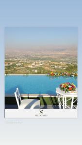 Ein Tisch und Stühle auf einem Balkon mit Blick auf einen See in der Unterkunft Vista Valle in Zahlé