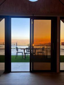 eine offene Tür zu einer Terrasse mit Tisch und Stühlen in der Unterkunft Vista Valle in Zahlé