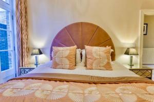 Un dormitorio con una cama grande con cabecero de madera. en The Art Deco Retreat-Ramsgate-Ground floor-Sea Views, en Ramsgate