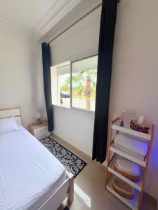 a bedroom with a bed and a window at lovely Apartment Rental with Pool in Asilah