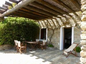 a patio with a table and chairs under a wooden pergola at Anastasia Luxury Villas in Gavrio