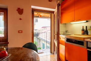 une cuisine avec des armoires orange et une table dans l'établissement Elegant Colorful Apartment - Verona Apartments, à Vérone