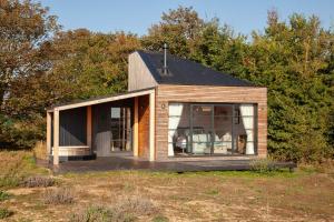 a small wooden house in the middle of a field at Cabu by the sea in Dymchurch