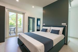 a bedroom with a large bed and a balcony at Floral Apartment in Castellammare di Stabia