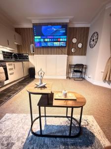 a living room with a table and a tv on the wall at The Coral Stay by Station in Cambridge
