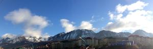 a view of a mountain range with buildings and clouds at Patagonia Austral Apartamentos in Ushuaia