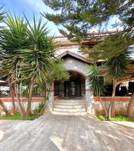 a building with palm trees in front of it at Luxury Villa Neighboring Oludeniz in Fethiye