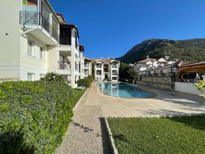 un edificio con piscina al lado de un edificio en Symbola Apartment 2 bedrooms in Hisaronu, en Fethiye