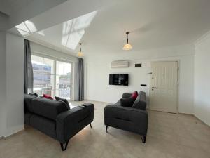 Una sala de estar con dos sofás y un televisor. en Symbola Apartment 2 bedrooms in Hisaronu, en Fethiye