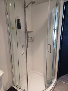 a shower with a glass door in a bathroom at Commercial Inn in Saint Dennis +13 photos
