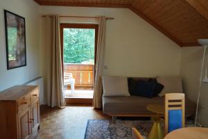 a living room with a couch and a large window at Apartmenthaus Schneider in Sielach