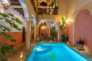 an indoor swimming pool in a building with a swimming pool at Riad Itrane in Marrakech