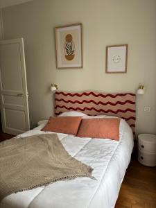 a bedroom with a large bed with a red headboard at Maison Mère in Arnac-Pompadour