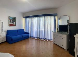 a living room with a blue couch and a television at Appartamento Albatros, Juan Dolio in Juan Dolio
