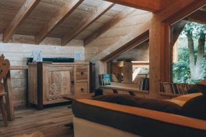 a living room with a couch and a wooden ceiling at Chalet familial d'exception - Foux d'Allos in Allos