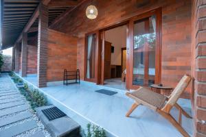 a patio with a chair on a house at Nukulla House in Tumbak Bayuh
