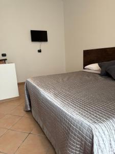 a bedroom with a bed and a tv on the wall at La Maison di Vicolo Torre in Uboldo