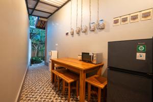 a kitchen with a wooden table and a refrigerator at Nukulla House in Tumbak Bayuh