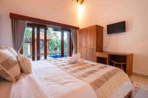 a bedroom with a large bed and a television at Nukulla House in Tumbak Bayuh