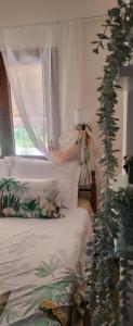 a bedroom with a bed with a curtain and a plant at Alina s House TRANI AMMOUDA HALKIDIKI in Ormos Panagias