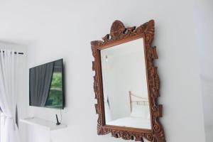 a mirror hanging on a wall next to a window at Studio near MetrôTietê, Anhembi and EXPO in Sao Paulo