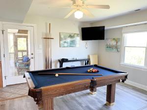 une table de billard dans un salon avec un ventilateur de plafond dans l'établissement SNH263 Gone Coastal, à Nags Head