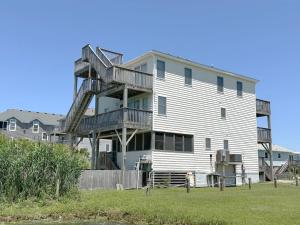 une grande maison blanche avec un escalier de secours dans l'établissement SNH263 Gone Coastal, à Nags Head