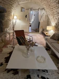 a living room with a white table and a couch at Le Castel in Châteauneuf-du-Pape
